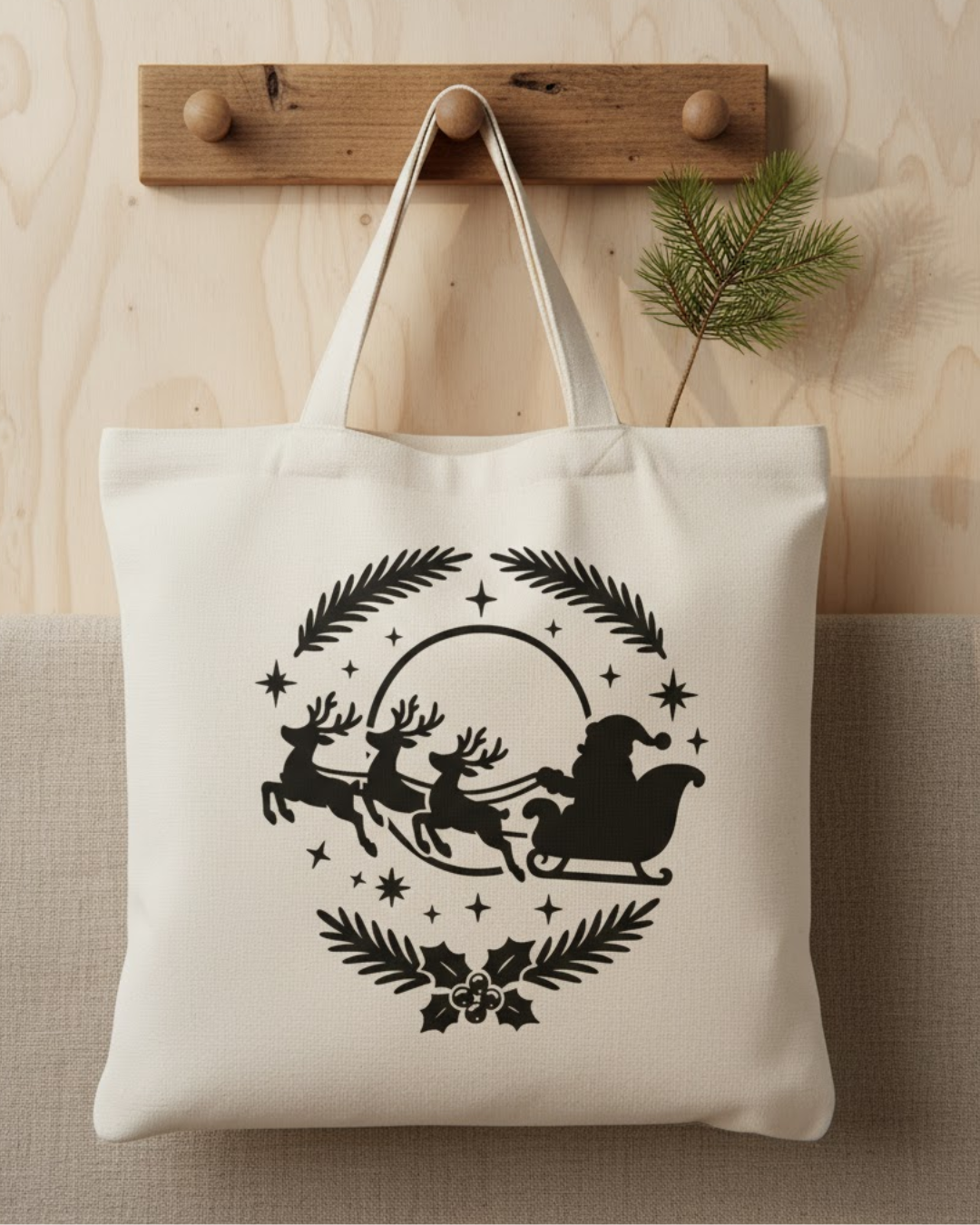 Beige Stofftasche mit schwarzem Aufdruck von Weihnachtsmann im Schlitten, gezogen von drei Rentieren, umgeben von Sternen und Tannenzweigen.