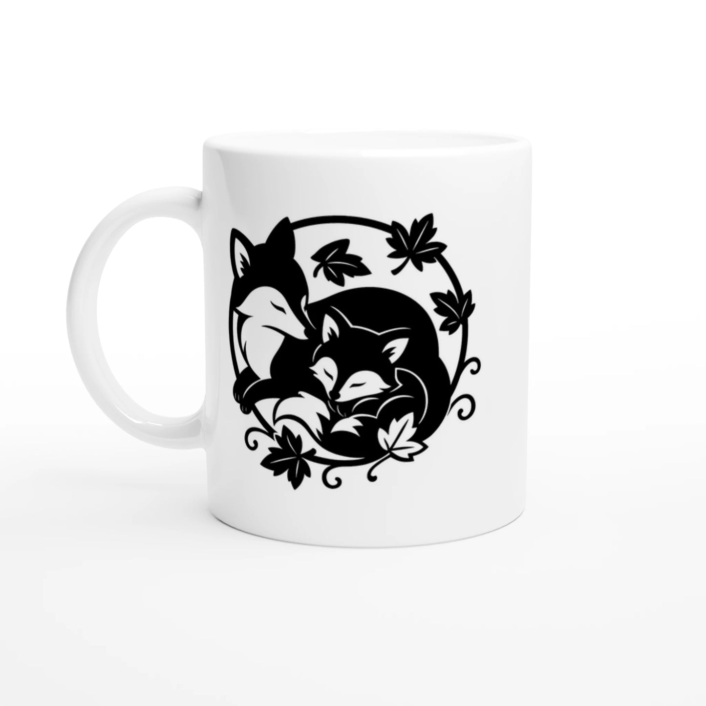 Weiße Tasse mit schwarz-weißem Motiv zweier sich aneinander schmiegender Füchse, umgeben von Blättern und Ranken.