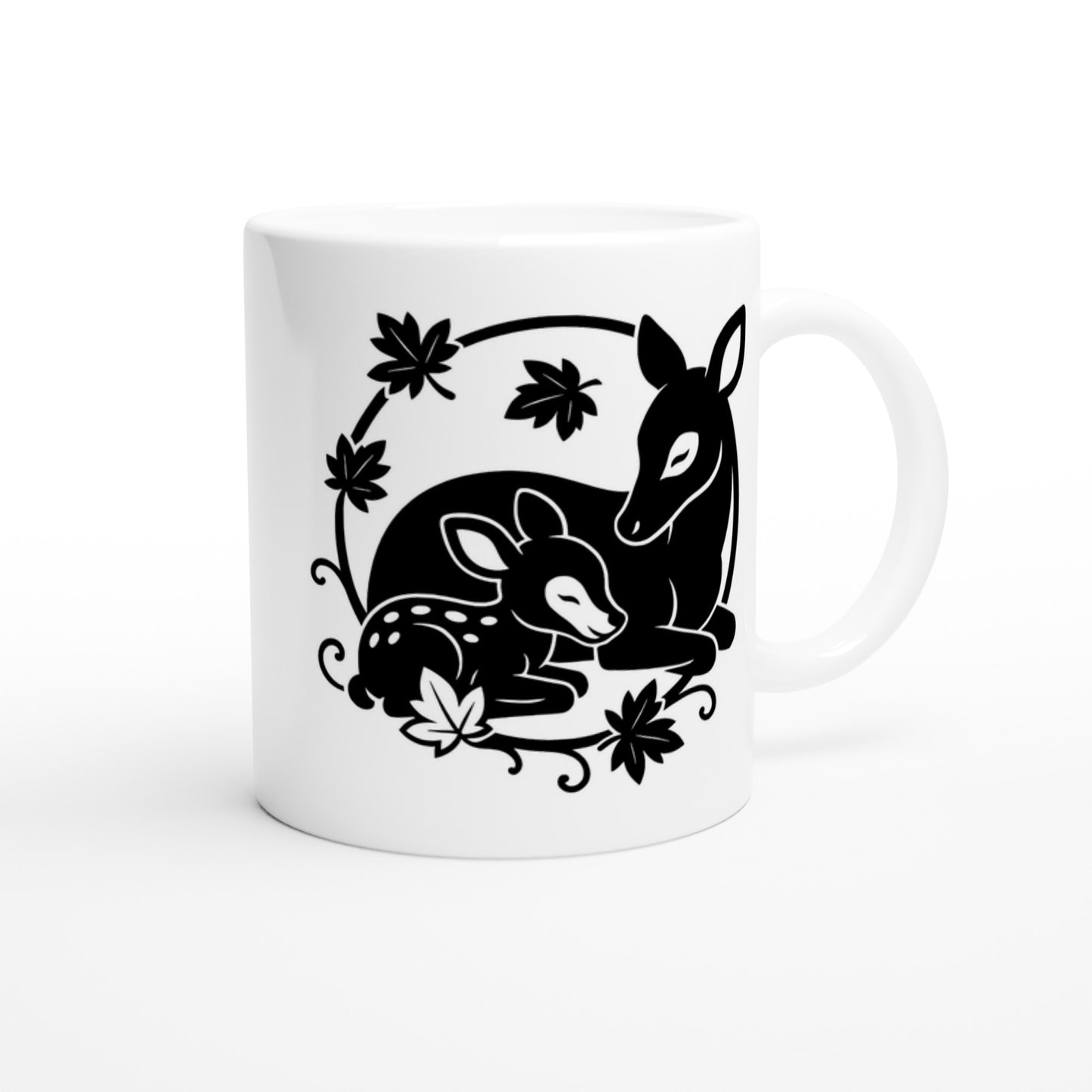 Weiße Tasse mit schwarz-weißer Linienzeichnung von einem liegenden Reh und einem liegenden Rehkitz, umgeben von Blättern.