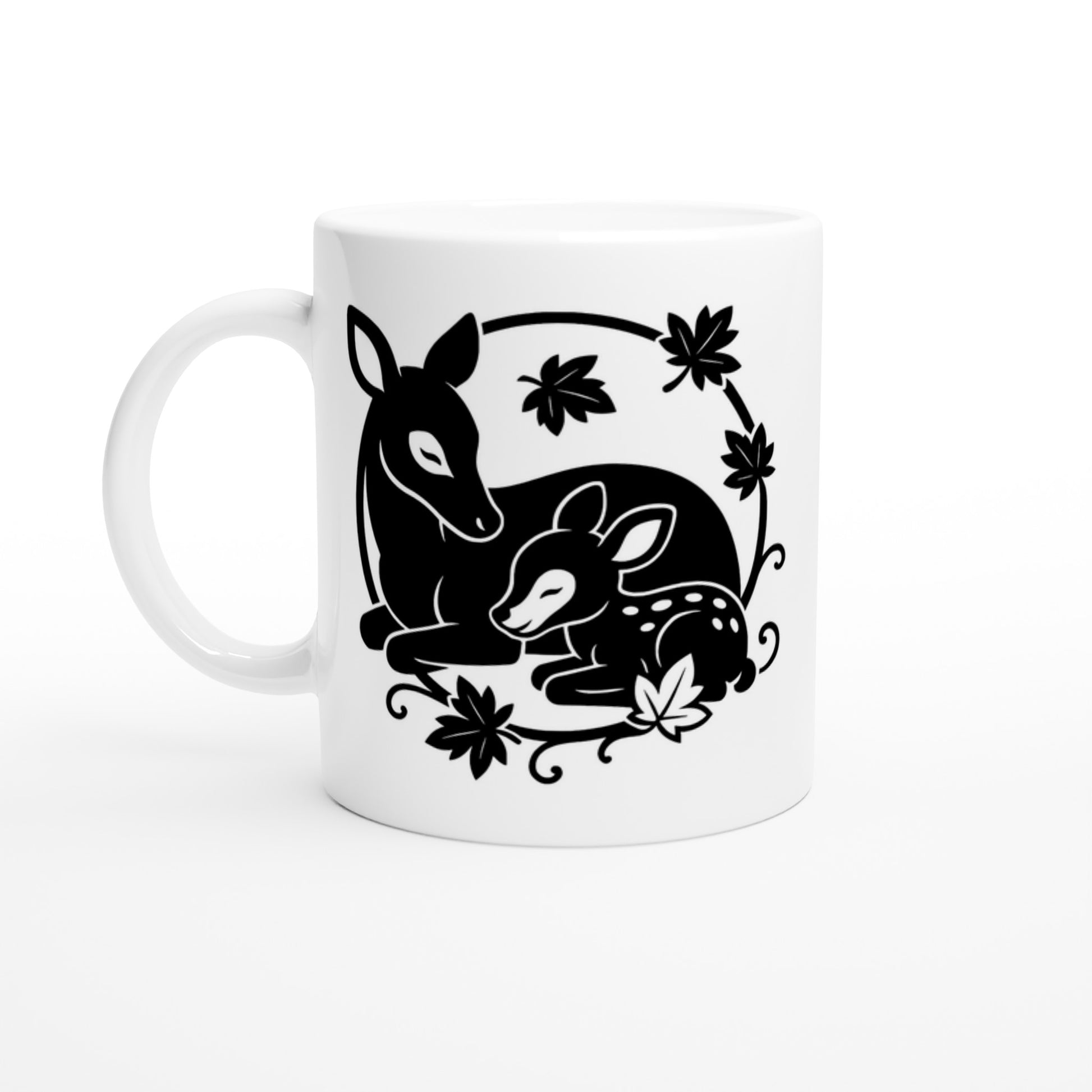 Weiße Tasse mit schwarz-weißer Linienzeichnung von einem liegenden Reh und einem liegenden Rehkitz, umgeben von Blättern.